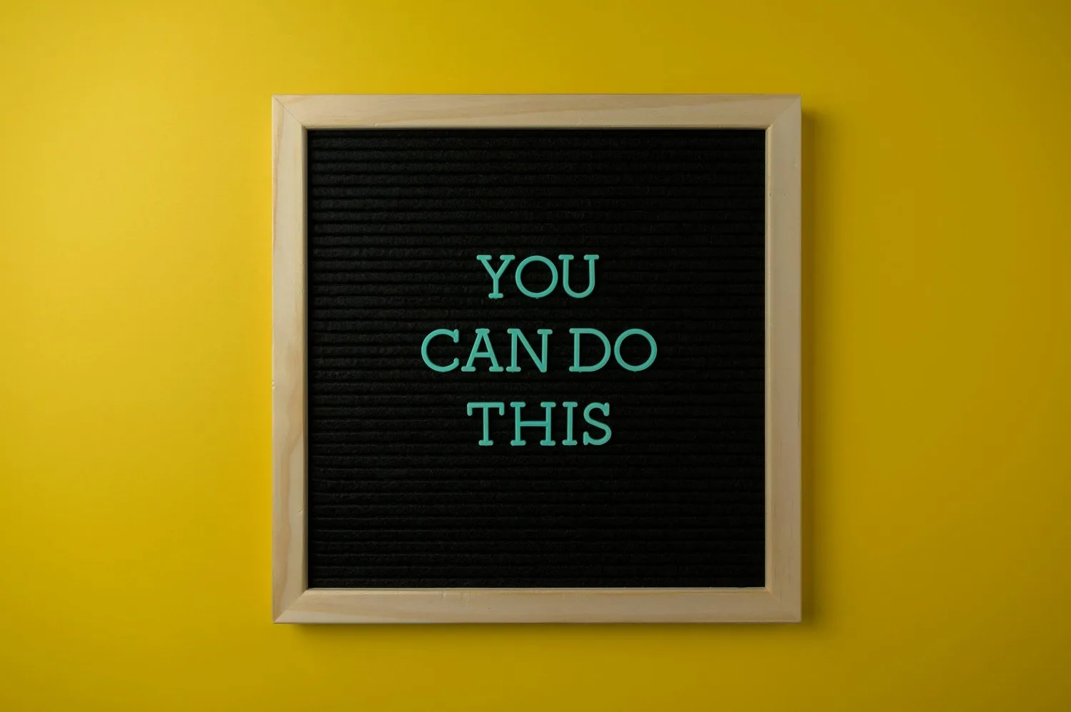 A black letter board on a yellow wall reads "You can do this."